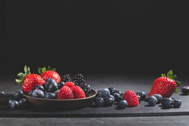 Koyu arkaplanda, kopyalama alanı olan çeşitli meyveler..