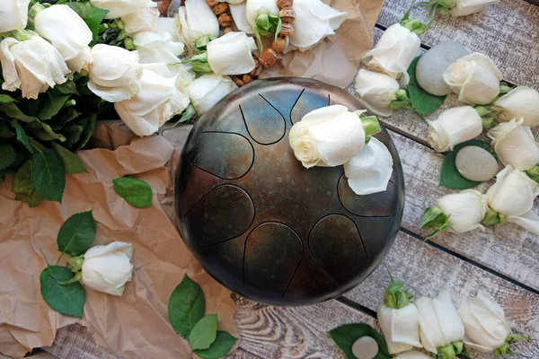 The Handpan is traditional ethnic drum musical instrument with roses background. — Stock Photo, Image