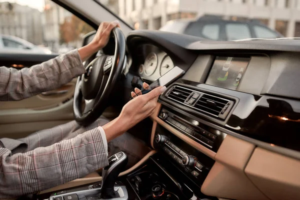 A verificar e-mail. Foto recortada de uma mulher segurando seu smartphone enquanto dirigia um carro — Fotografia de Stock