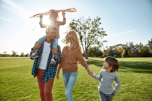 Bu zinciri kıramazsın. Mutlu bir aile uçurtma oynuyor. Açık hava aile hafta sonu — Stok fotoğraf