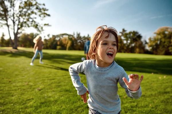 Tant de plaisir. Famille heureuse jouant avec une balle sur prairie — Photo