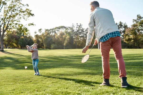 Hayata hazırlanıyorum. Baba kızıyla birlikte güneşli bir günde parkta badminton oynuyor. — Stok fotoğraf