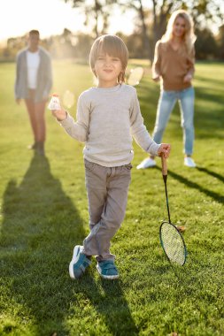 Oynayalım. Mutlu ve güzel bir aile güneşli bir günde parkta vakit geçirir.