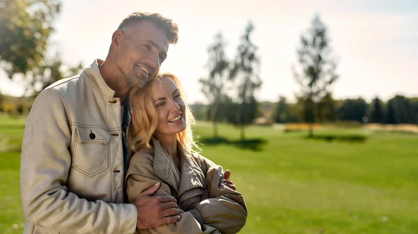 Zonnige dag met jou. Portret van een romantisch koppel in liefde knuffelend en lachend terwijl ze in het midden van het prachtige park staan — Stockfoto