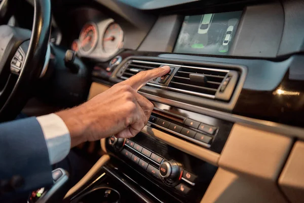 Signals on the road. Cropped photo of male hand pushing the emergency gang button while sitting in the car — Stock Photo, Image