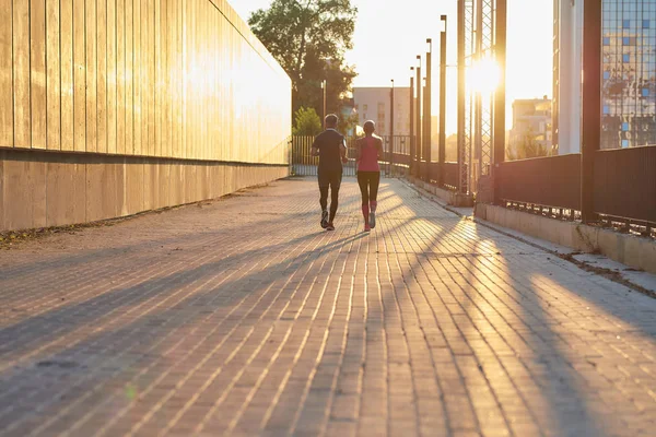 Fare sport insieme. Vista posteriore di una coppia in abbigliamento sportivo che corre insieme per la strada della città. Coppia fitness — Foto Stock