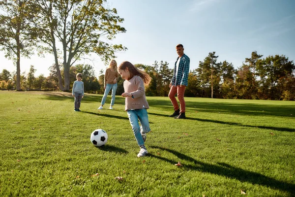 La foi, la famille, le football. Famille heureuse jouant avec une balle sur prairie — Photo