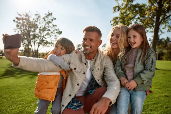 Smile at the camera. Happy family taking selfies outdoors — 图库照片