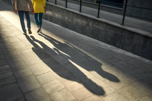 Foto ritagliata di una coppia in abiti casual che si tiene per mano e cammina insieme per la strada della città — Foto Stock