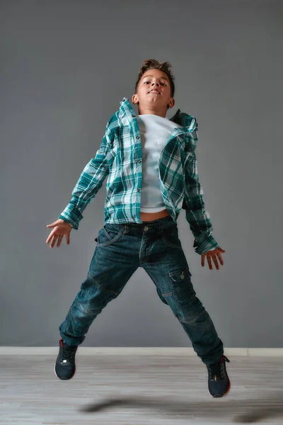 Child with lots of energy. Full length portrait of excited little boy in casual clothes jumping and looking at camera in studio — Stock Photo, Image