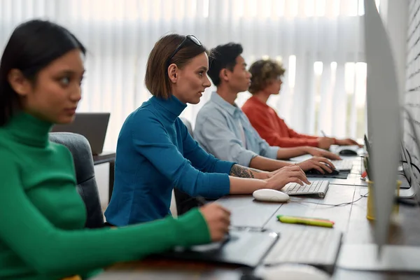 Office routine. Young creative people in casual wear working on computers while sitting in the modern loft office — Stock Photo, Image