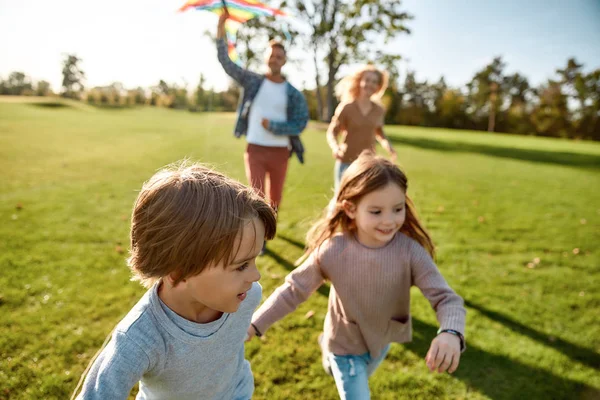 Barn är levande juveler. Lycklig familj som leker drake. Familjehelg utomhus — Stockfoto