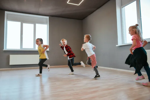 Bambini attivi. Piccoli e felici ragazzi e ragazze che corrono nello studio di danza. Lezione di coreografia — Foto Stock