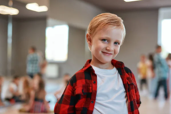 Chico feliz. Retrato de un lindo niño con ropa casual mirando a la cámara y sonriendo mientras está de pie en el estudio de baile — Foto de Stock