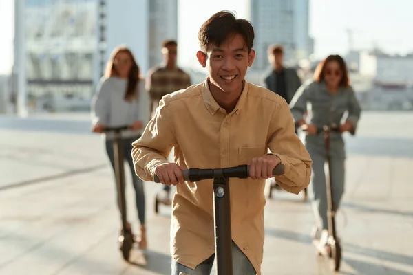 Best entertainment. A group of friends riding kick scooters and segways on a sunny day