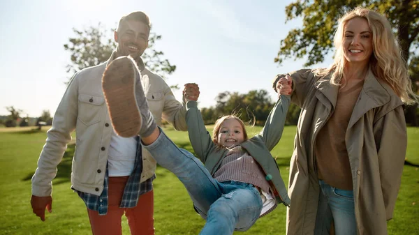 El hogar es donde está mi familia. Padres felices levantando chica juguetonamente — Foto de Stock