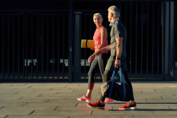 Ci motivamo sempre a vicenda. Piena lunghezza della coppia attiva di mezza età in abbigliamento sportivo tornando a casa dopo l'allenamento attivo insieme — Foto Stock