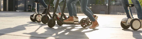 Viva a vida em duas rodas. Joyful amigos montando scooters pontapé e segways — Fotografia de Stock