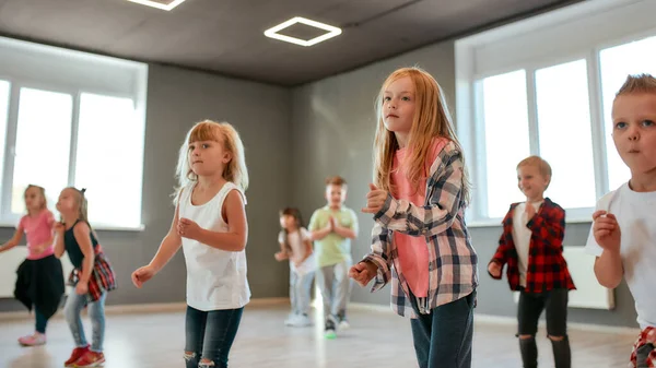 Love to move. Group of cute and active children in casual clothes learning a modern dance in the dance studio. Choreography class. Activity. Hobby — 스톡 사진
