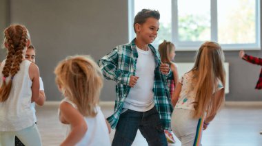 Having fun. Group of positive children learning a modern dance in the dance studio. Choreography concept