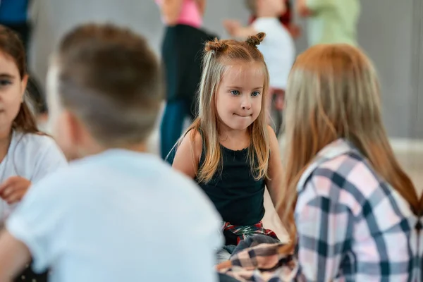 Portrait of children talking with each other while sitting on the floor and having a break in the dance studio — Stok fotoğraf