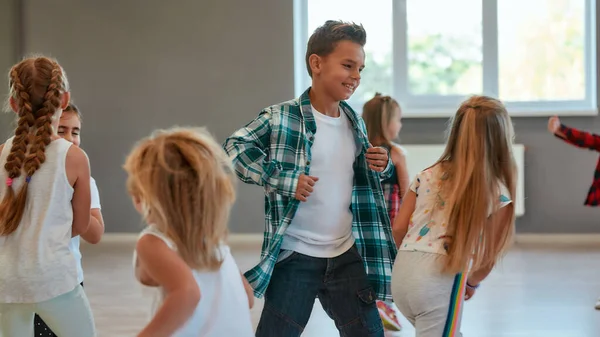 Divirtiéndose. Grupo de niños positivos aprendiendo una danza moderna en el estudio de danza. Concepto de coreografía —  Fotos de Stock