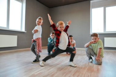 Hip hop tarzı. Şık giyinmiş, dans eden ve stüdyoda poz veren bir grup şirin çocuk. Koreografi dersi. Çocuklar ve spor. Tam uzunluk