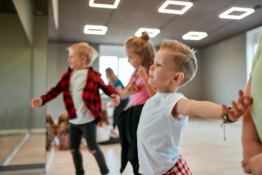 Modern dansçılar. Bir grup modaya uygun çocuk koreografi dersinde modern bir dans öğreniyor. Dans stüdyosu