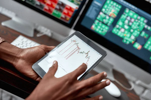 For the things you need. Close up shot of hands holding tablet pc. Trader is using touch screen tablet for analyzing stock market chart, while working in the office — Stock Photo, Image