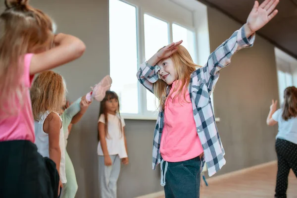 힙합을 즐겨요. 어린 소녀가 안 무수업을 듣는 동안 몸짓을 하며 즐겁게 노는 모습. 무용 학교에서 새로운 춤을 배우고 있는 아이들의 그룹 — 스톡 사진