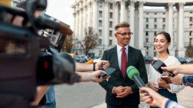 Burası bir gazete bayii. Politikacılarla röportaj yapan gazeteciler. Gazetecilik endüstrisi, canlı yayın konsepti.