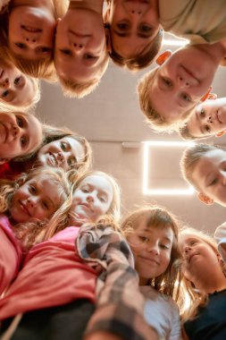 Mutlu dans takımı. Bir grup pozitif erkek ve kız ve bayan dans hocaları. Dans stüdyosunda kameraya gülümseyen mutlu çocukların alt görüntüsü.