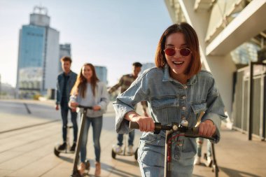Keyfini çıkar. Güneşli bir günde scooter ve segway kullanan bir grup arkadaş.