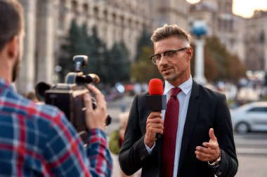 Önemli olan şeyi kaçırıyor musun? Şehir sokağında haberleri sunan profesyonel bir muhabir. Gazetecilik endüstrisi, canlı yayın konsepti