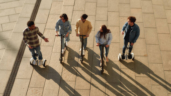 Создай воспоминания для своей жизни. Радостные друзья катаются на скутерах и сегвеях
