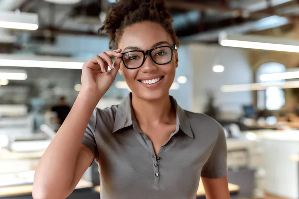 Tu sonrisa siempre será tu mayor habilidad. Atractivo trabajador afroamericano posando en el cargo — Foto de Stock