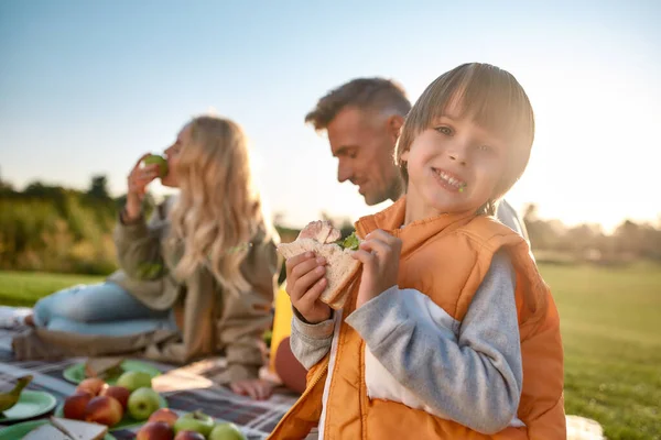 Samen picknicken. Gelukkig gezin brengt tijd door in het park op een zonnige dag — Stockfoto