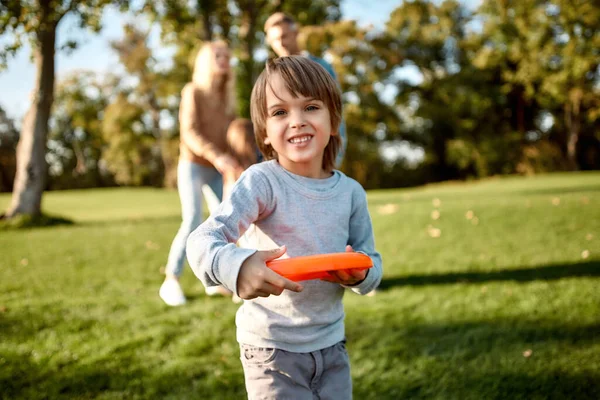 Mode de vie sain. Petit garçon jouant au frisbee dans le parc par une journée ensoleillée — Photo