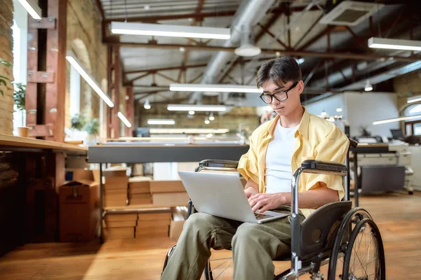 Talent wint. Man in een rolstoel aan het werk in het kantoor — Stockfoto