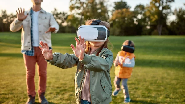 Fin de semana digital Familia jugando en gafas de realidad virtual al aire libre —  Fotos de Stock