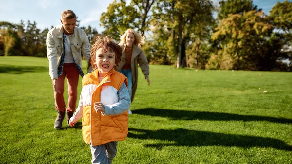 You can t catch me. Excited family running outdoors on a sunny day — Stockfoto
