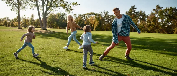 Recuerda la hora. Familia emocionada corriendo al aire libre en un día soleado — Foto de Stock