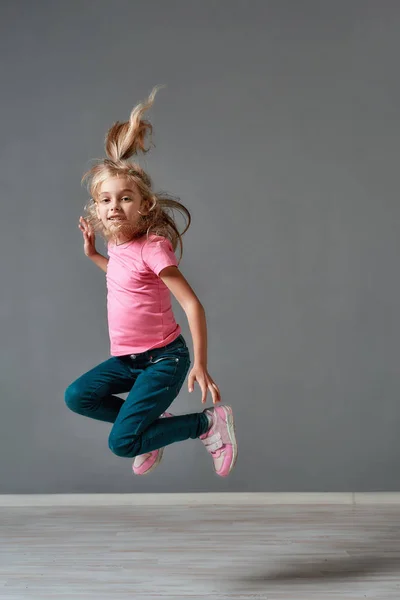 Having fun. Portrait of a cute and excited little girl in casual clothes jumping in studio and looking at camera. Happy children. Childhood. Motion — 스톡 사진