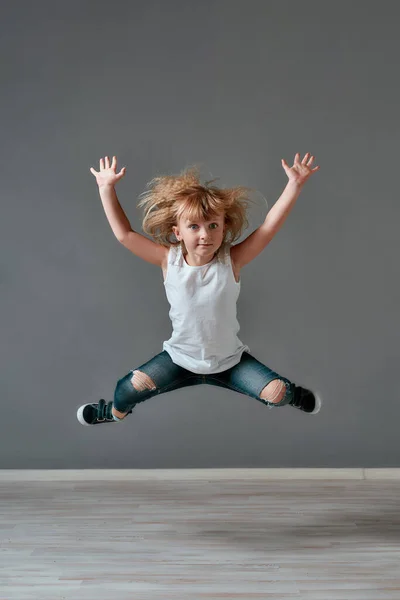 Crazy child. Full length portrait of a cute and excited little girl in casual clothes jumping in studio and looking at camera — 스톡 사진