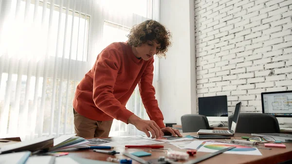 Werken aan een nieuw project. Gericht jonge ontwerper in casual op zoek naar een aantal kleurstalen terwijl staan in het moderne kantoor. Creatief agentschap — Stockfoto