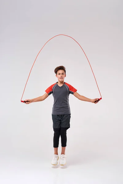 This is how I jump. Full-length shot of a teenage boy engaged in fitness, skipping using jump rope. Isolated on white background. Sport, training, fitness, active lifestyle concept — Stock Photo, Image