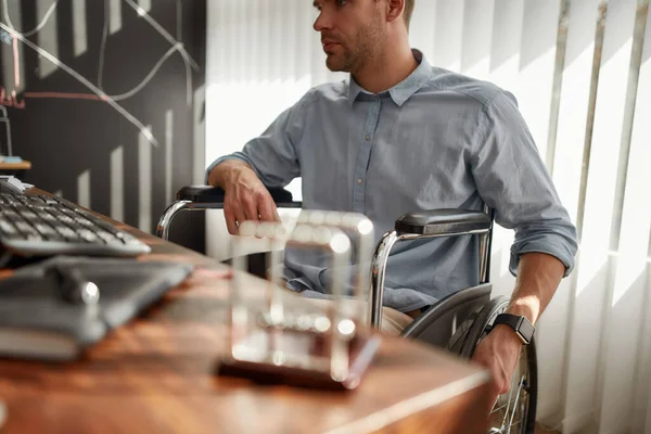 Een dag in functie. Gehakte foto van drukke zakenman in een rolstoel aan het werk op zijn werkplek in het moderne kantoor — Stockfoto