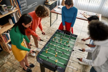 Çalışmak için en iyi yer. Modern ofiste genç ve mutlu çok kültürlü insanların en iyi görünümü futbol masası futbolu giymesidir. Ofis aktiviteleri. Birlikte eğleniyoruz. Mutlu çalışanlar