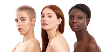 Multi ethnic beauty. Three gorgeous multicultural young women with naked shoulders looking at camera while standing close to each other in studio against white background