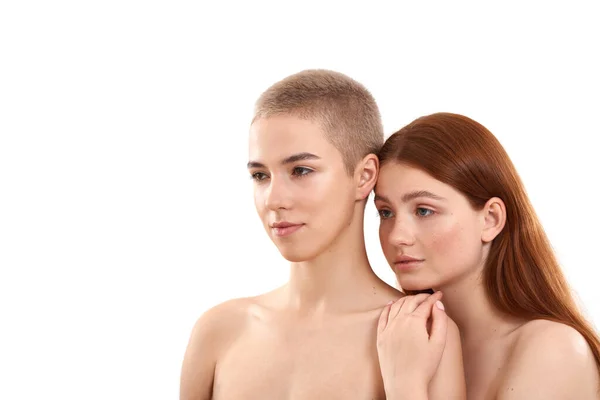 Two different girls. Beauty portrait of young blonde and redhead women looking away while posing naked against white background. Natural beauty — 图库照片
